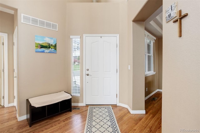 entryway featuring baseboards, visible vents, and light wood finished floors