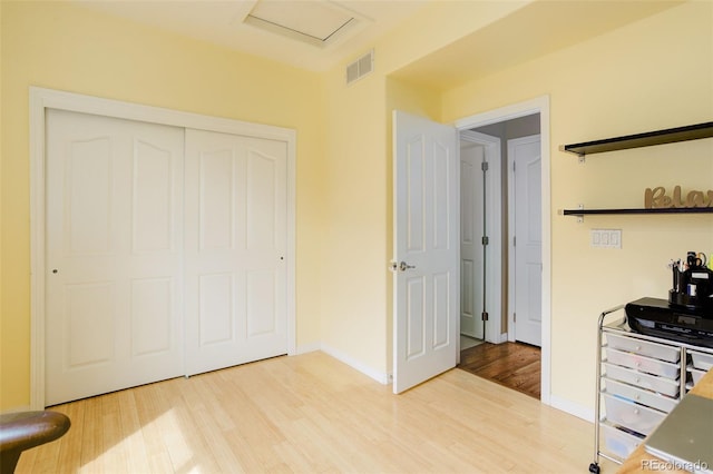 office with visible vents, attic access, baseboards, and wood finished floors