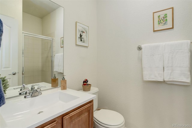 bathroom with toilet, tiled shower, and vanity