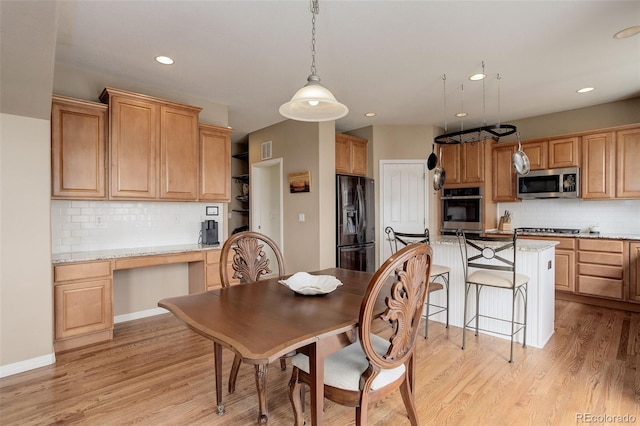 dining space with light wood-type flooring, recessed lighting, built in desk, and visible vents