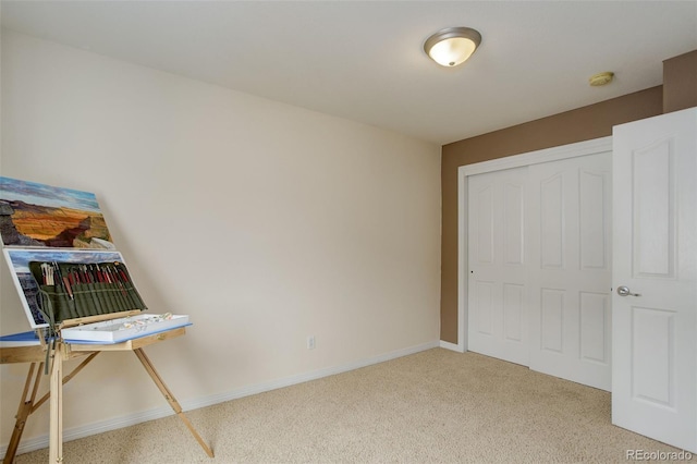 unfurnished bedroom with baseboards, light carpet, and a closet