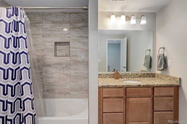 bathroom featuring vanity, visible vents, and shower / tub combo