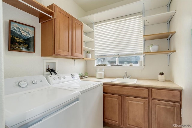laundry area with separate washer and dryer, a sink, and cabinet space