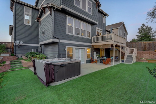 back of house featuring stairs, a hot tub, cooling unit, a patio area, and a yard