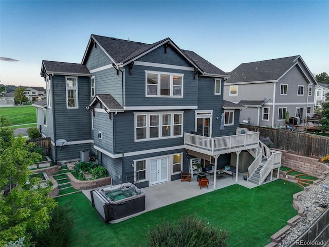 rear view of property featuring a wooden deck, stairway, a patio area, french doors, and a lawn