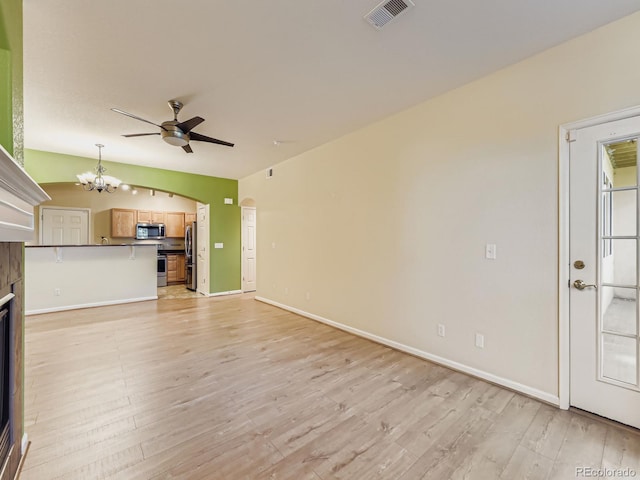 9896 W Freiburg Dr Unit 1D, Littleton, CO 80127 - unfurnished living room featuring a chandelier, ceiling fan, light wood-style floors, and arched walkways