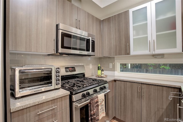 2138 N Glenarm Pl, Denver, CO 80205 - kitchen with appliances with stainless steel finishes, modern cabinets, tasteful backsplash, and light brown cabinetry