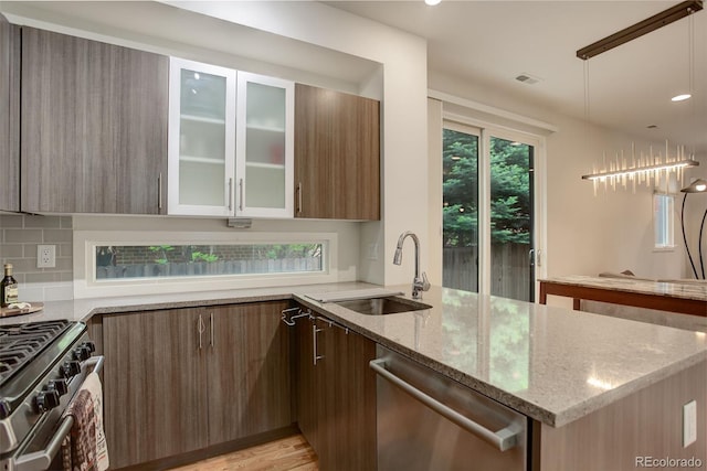 2138 N Glenarm Pl, Denver, CO 80205 - kitchen with appliances with stainless steel finishes, light stone countertops, modern cabinets, a sink, and recessed lighting