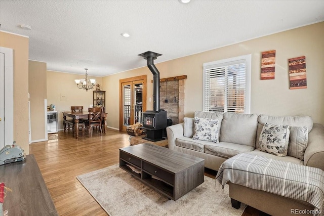 living room with hardwood / wood-style flooring, a healthy amount of sunlight, a textured ceiling, and a wood stove