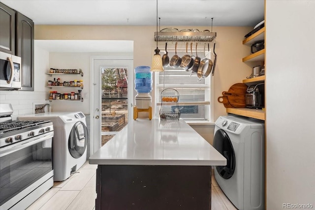 kitchen featuring a kitchen island, decorative light fixtures, washer / dryer, backsplash, and stainless steel appliances