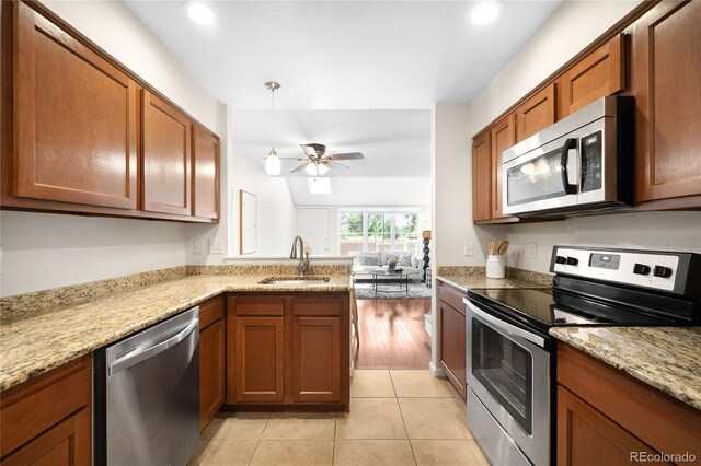 7373 E Iowa Ave Unit 1124, Denver, CO 80231 - kitchen featuring appliances with stainless steel finishes, ceiling fan, brown cabinetry, a peninsula, and recessed lighting