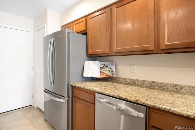 7373 E Iowa Ave Unit 1124, Denver, CO 80231 - kitchen featuring stainless steel appliances, brown cabinetry, and light stone counters
