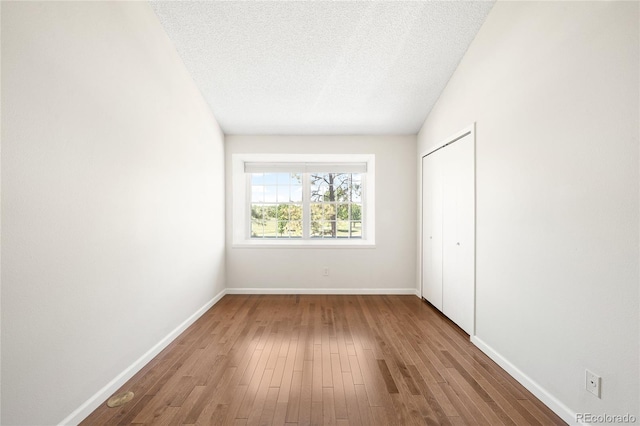 7373 E Iowa Ave Unit 1124, Denver, CO 80231 - unfurnished bedroom with wood finished floors, a closet, and a textured ceiling