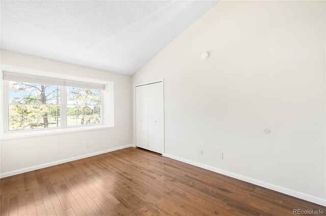 7373 E Iowa Ave Unit 1124, Denver, CO 80231 - unfurnished bedroom featuring wood finished floors, vaulted ceiling, and a closet