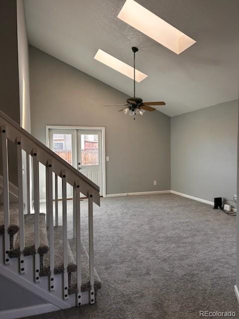 stairs featuring a skylight, carpet flooring, and a ceiling fan