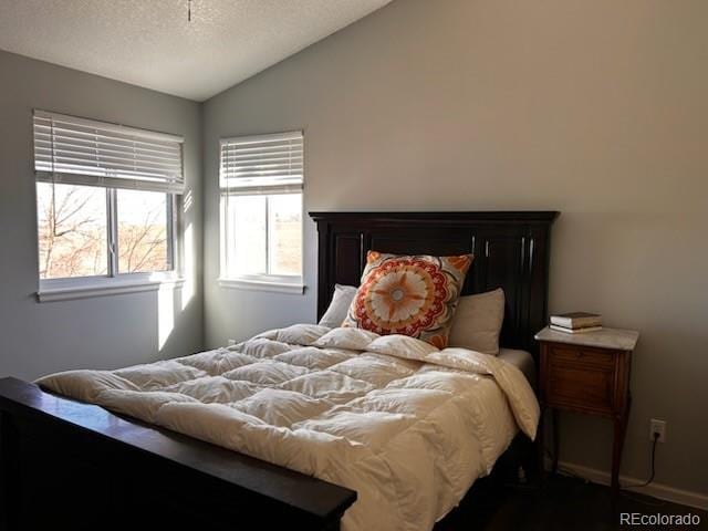 bedroom featuring a textured ceiling and vaulted ceiling