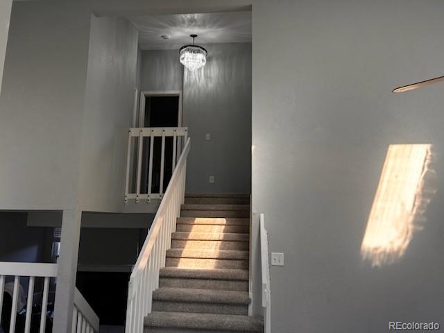 stairs featuring an inviting chandelier