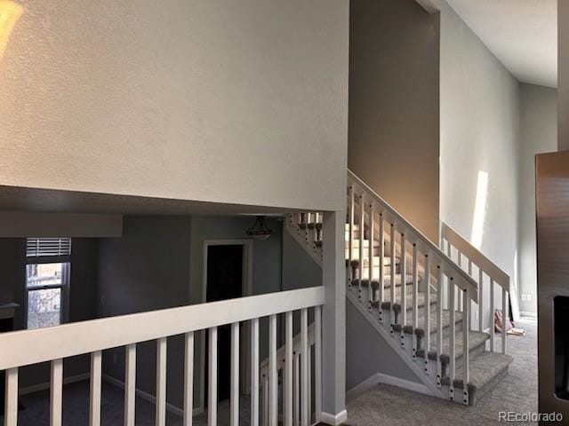 stairs featuring carpet flooring and a towering ceiling