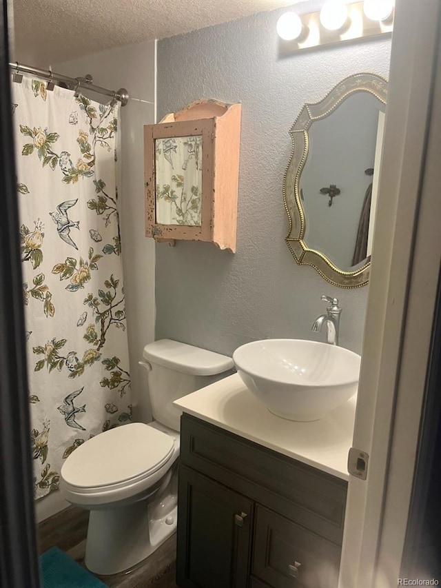 full bathroom with a shower with curtain, toilet, a textured ceiling, vanity, and a textured wall