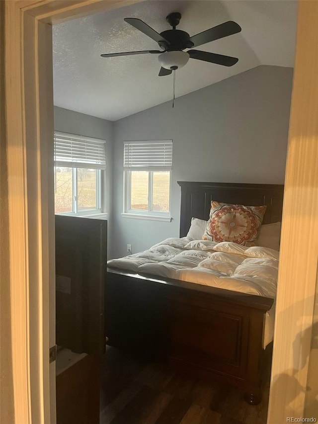 bedroom with a textured ceiling, a ceiling fan, lofted ceiling, and wood finished floors