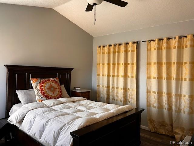 bedroom featuring dark wood finished floors, ceiling fan, and vaulted ceiling