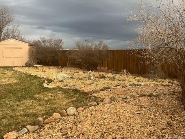 view of yard with an outbuilding, fence, and a shed