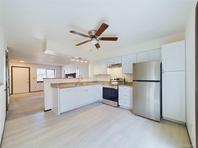 kitchen featuring appliances with stainless steel finishes, white cabinetry, sink, kitchen peninsula, and ceiling fan