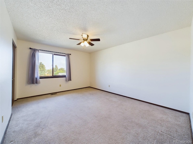 empty room with a textured ceiling, ceiling fan, and light carpet