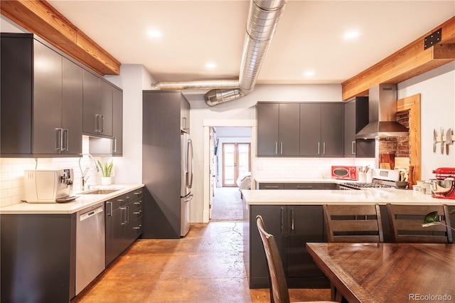 117 Elati St Unit 1, Denver, CO 80223 - kitchen with appliances with stainless steel finishes, wall chimney exhaust hood, a peninsula, concrete floors, and decorative backsplash
