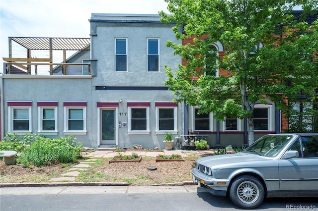 117 Elati St Unit 1, Denver, CO 80223 - view of front of home with stucco siding and a balcony