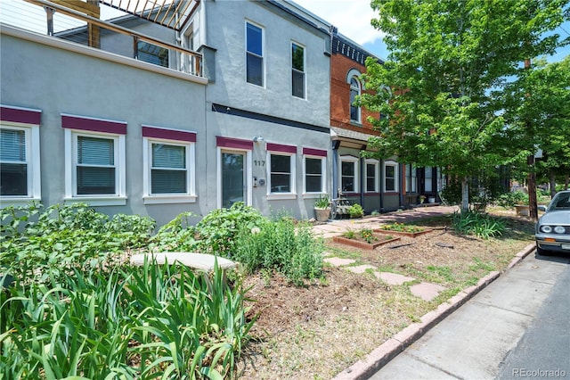 117 Elati St Unit 1, Denver, CO 80223 - view of front of home featuring stucco siding and a vegetable garden