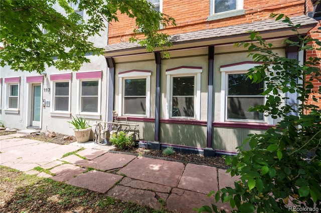 117 Elati St Unit 1, Denver, CO 80223 - view of property exterior featuring a shingled roof and stucco siding