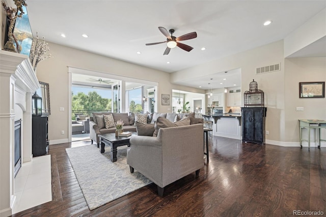 living room with ceiling fan and dark wood-type flooring