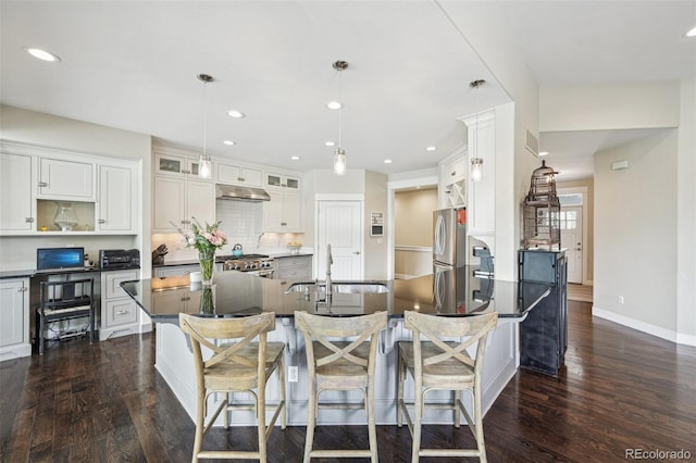 kitchen featuring white cabinets, sink, decorative light fixtures, dark hardwood / wood-style flooring, and stainless steel appliances