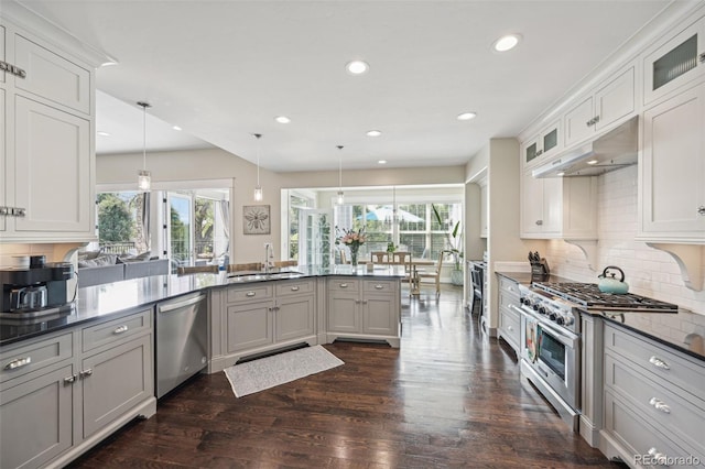 kitchen featuring white cabinets, appliances with stainless steel finishes, decorative light fixtures, and sink