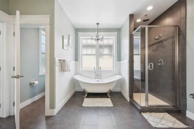 bathroom with plus walk in shower, a chandelier, and tile patterned floors