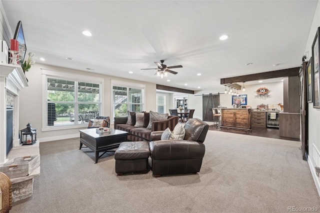 living room with ceiling fan, light colored carpet, and bar area