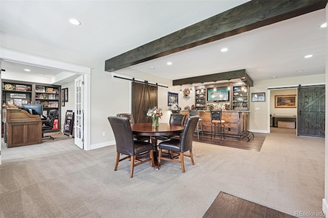 carpeted dining room with beamed ceiling, a barn door, built in features, and bar