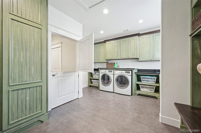 clothes washing area with washer and dryer, light tile patterned floors, and cabinets