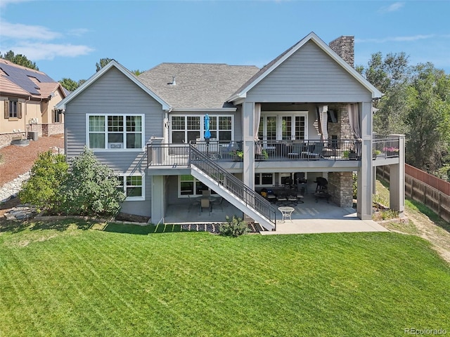 back of property with a wooden deck, a yard, and a patio