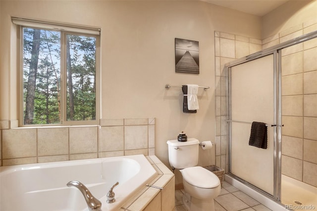 bathroom featuring tile patterned flooring, shower with separate bathtub, and toilet