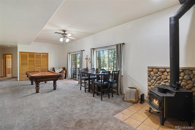 playroom featuring billiards, light colored carpet, ceiling fan, and a wood stove