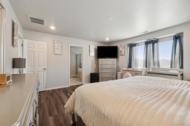 bedroom with dark hardwood / wood-style floors and connected bathroom