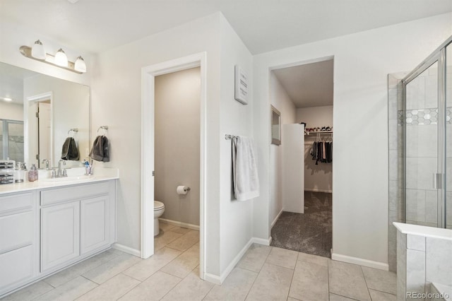 bathroom featuring vanity, a shower with shower door, toilet, and tile patterned floors