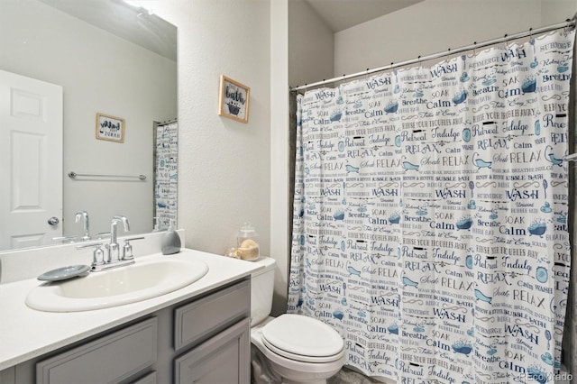 bathroom with walk in shower, vanity, and toilet