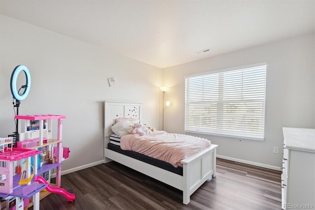 bedroom with dark hardwood / wood-style floors