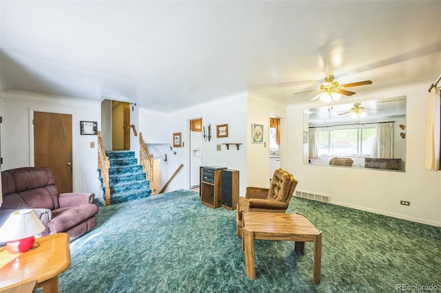 carpeted living room featuring stairway, baseboards, a ceiling fan, and visible vents