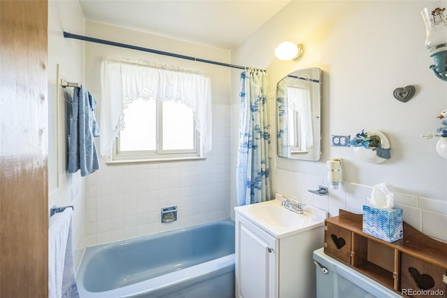 bathroom with vanity, tile walls, and shower / tub combo with curtain