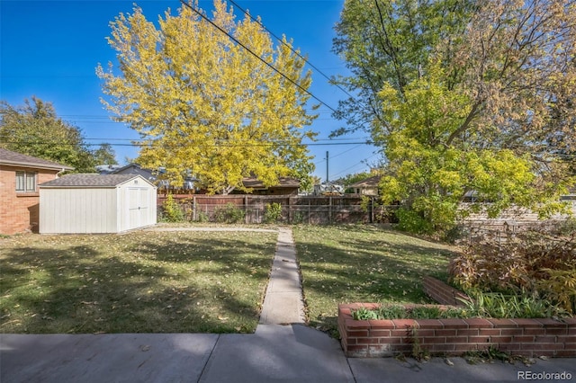 view of yard with an outbuilding, a fenced backyard, and a storage unit