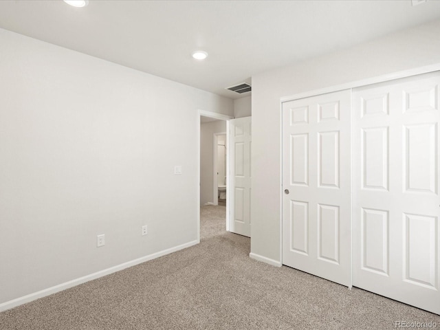 unfurnished bedroom featuring carpet flooring and a closet